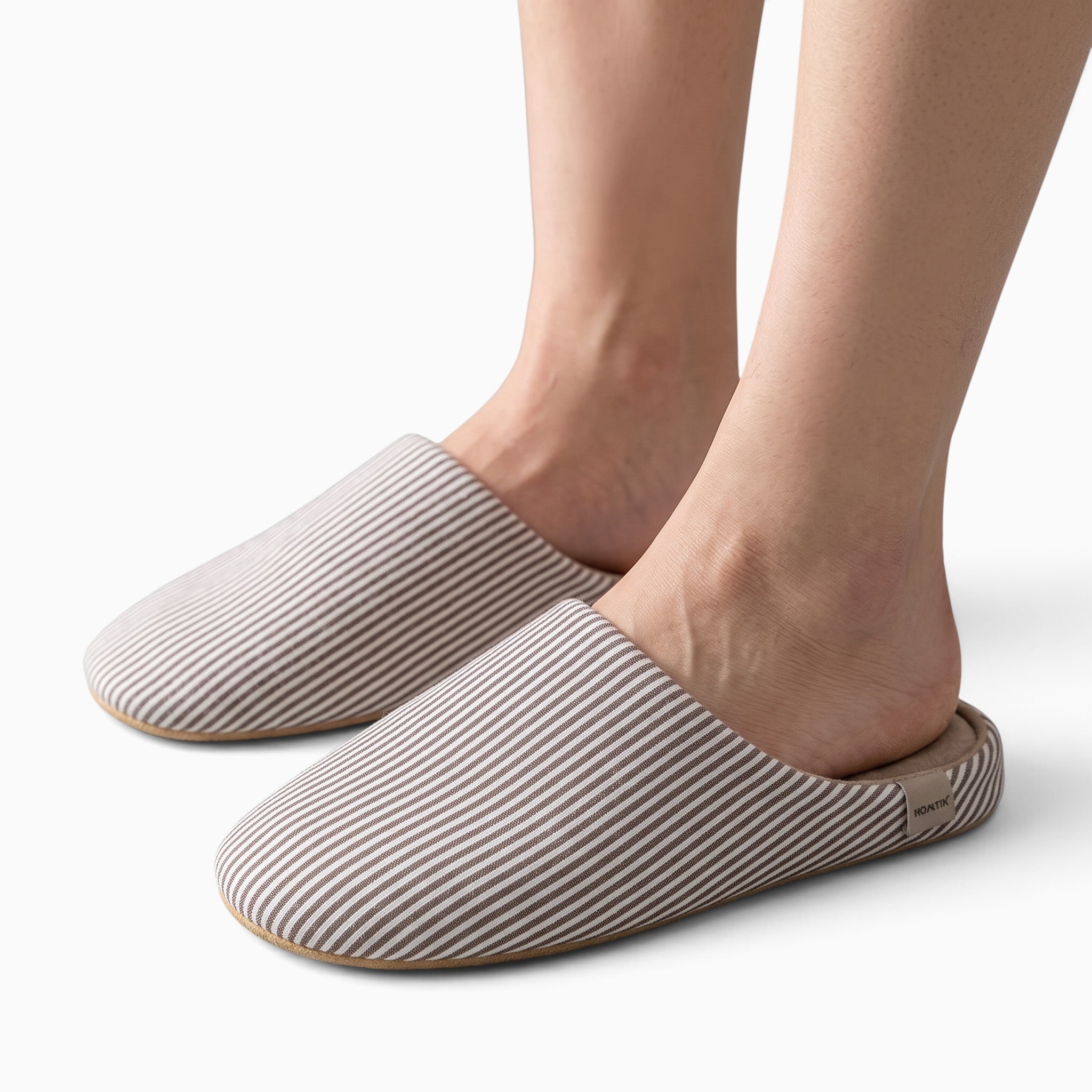 Paire de chaussons UnPeignoir à rayures beiges et blanches, modèle ouvert à l'arrière en tissu souple pour intérieur.