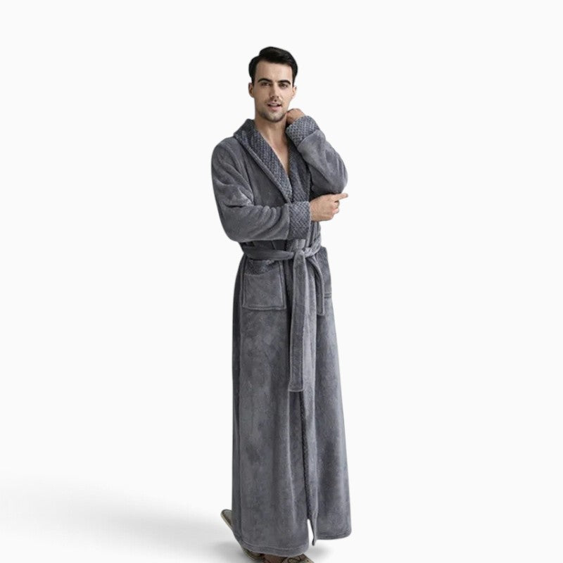 Homme portant un peignoir long en velours gris UnPeignoir, coupe élégante et confortable pour la détente à la maison.