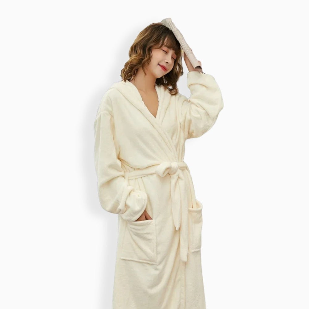 Femme souriante portant un peignoir polaire UnPeignoir blanc crème doux avec capuche et ceinture à nouer