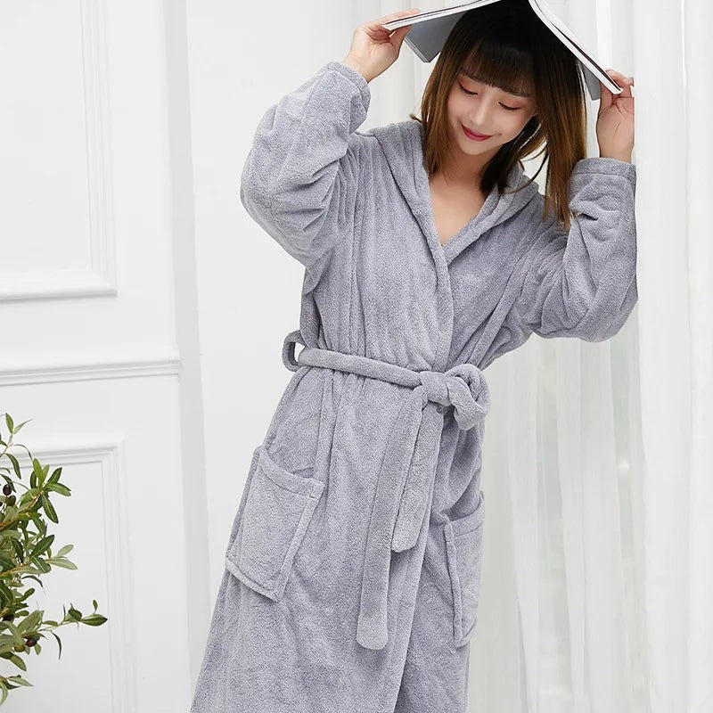 Femme portant un peignoir polaire gris UnPeignoir doux à capuche avec ceinture et poches pour un confort cocooning